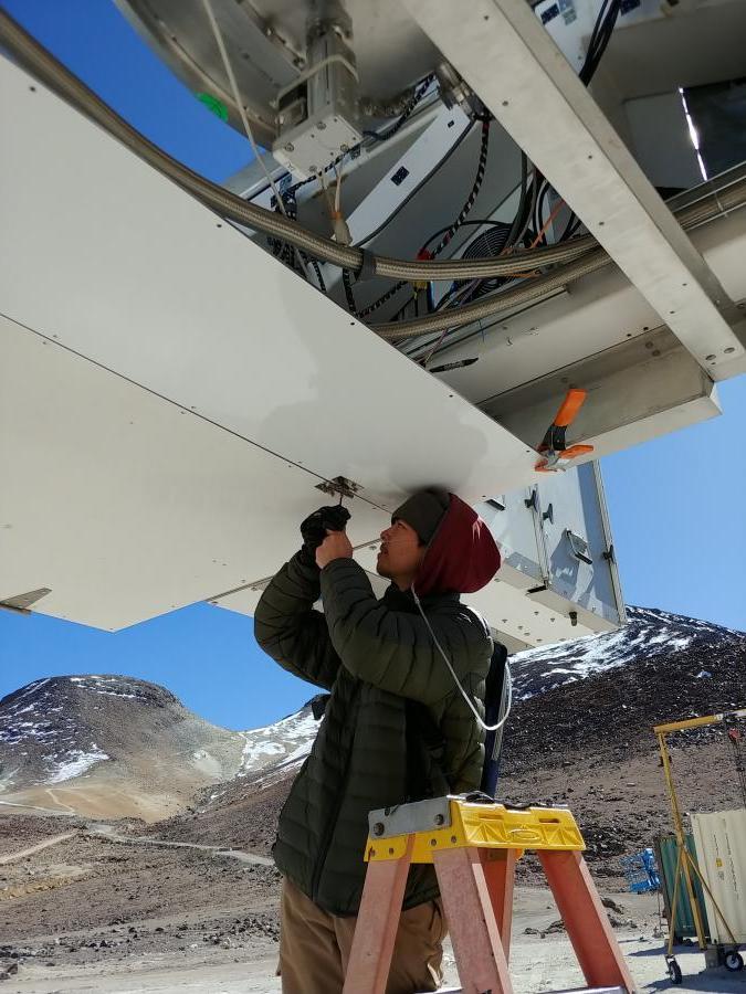 学生迈克尔·卢在17000英尺高空的望远镜上工作